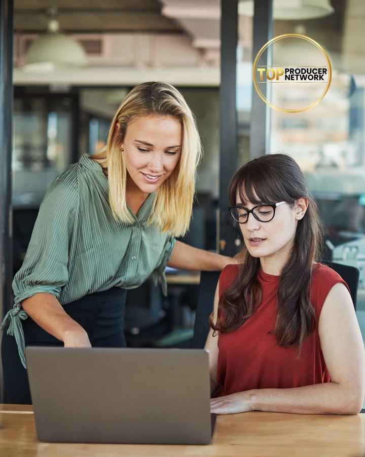 Two agents reviewing a follow-up plan on a laptop